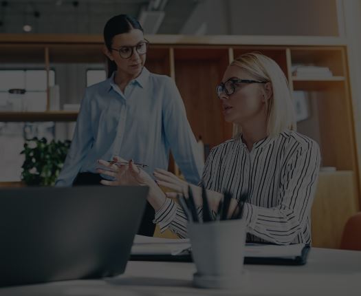 two women talking in an office setting